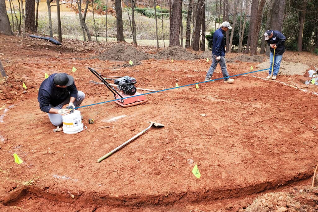 About Greenland Landscaping and Masonry masons using laser level to set grade of brick paving in Lawrenceville